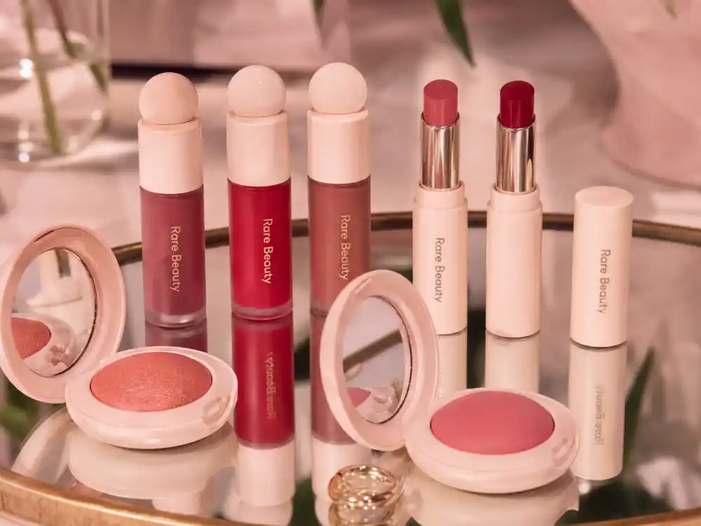 Rare Beauty products on vanity mirror reflecting how old is Selena Gomez entrepreneur era and beauty brand milestones