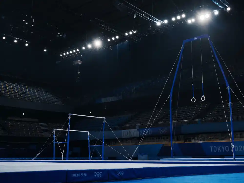 Olympic gymnastics arena interior reflecting how old is Simone Biles at industry peak — Rio, Tokyo, and Paris medal runs across three Olympic cycles