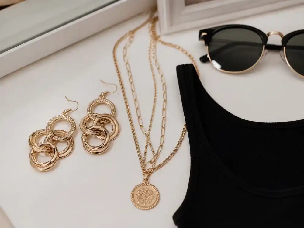 Gold statement earrings and layered necklaces elevating basics for how to dress like a celebrity on budget accessory codes