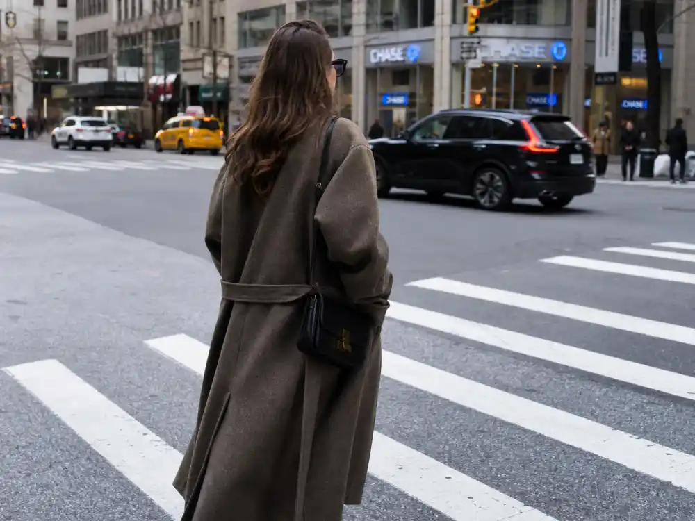 Oversized coat and sunglasses crosswalk look illustrating how to dress like a celebrity on budget off-duty street style