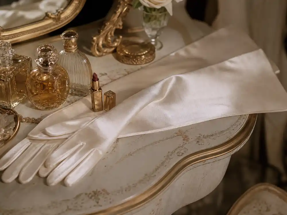 Ivory satin opera gloves on vintage vanity showing how to dress like Anya Taylor-Joy vintage glamour accessory discipline