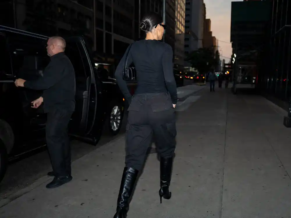 All-black cargo pants knee boots and slicked bun behind how to dress like Bella Hadid model off duty monochrome uniform