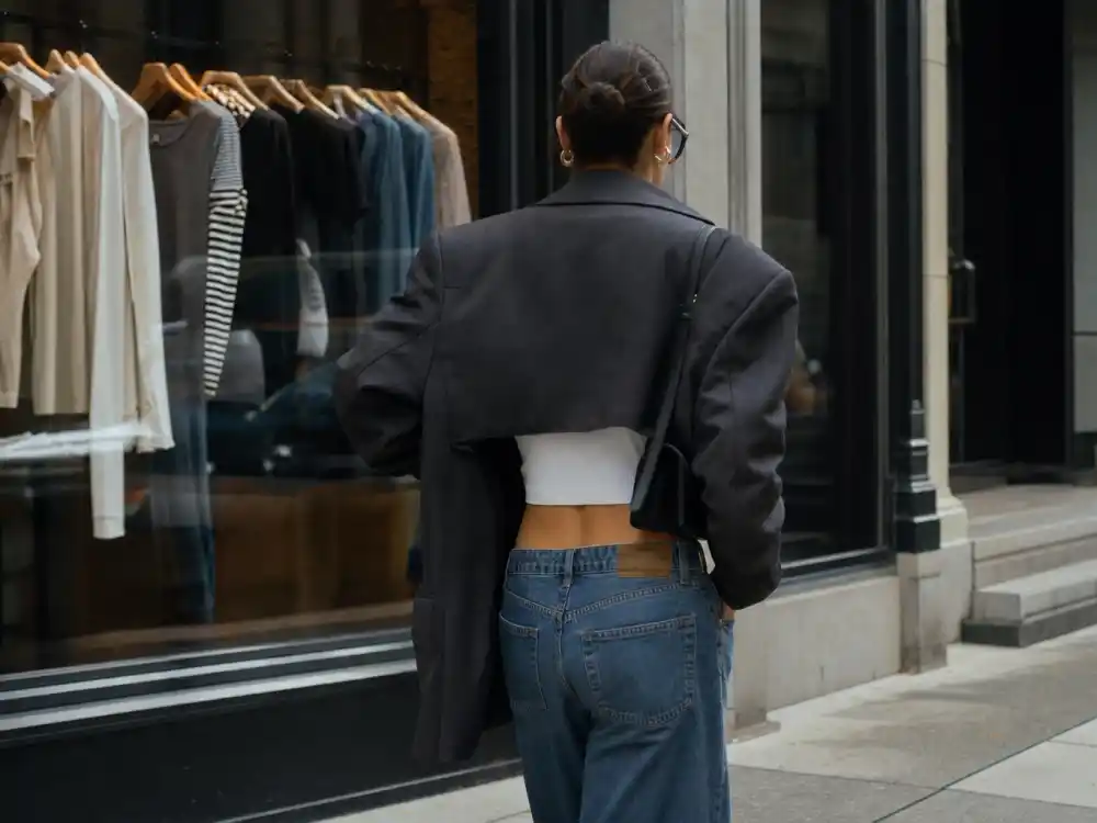 Oversized charcoal blazer over micro crop top defining how to dress like Bella Hadid model off duty layering contrast
