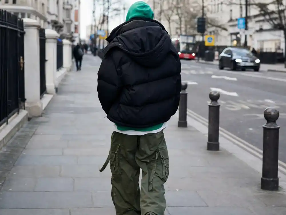 Layered oversized puffer jacket over neon hoodie showing how to dress like Billie Eilish oversized style volume stacking