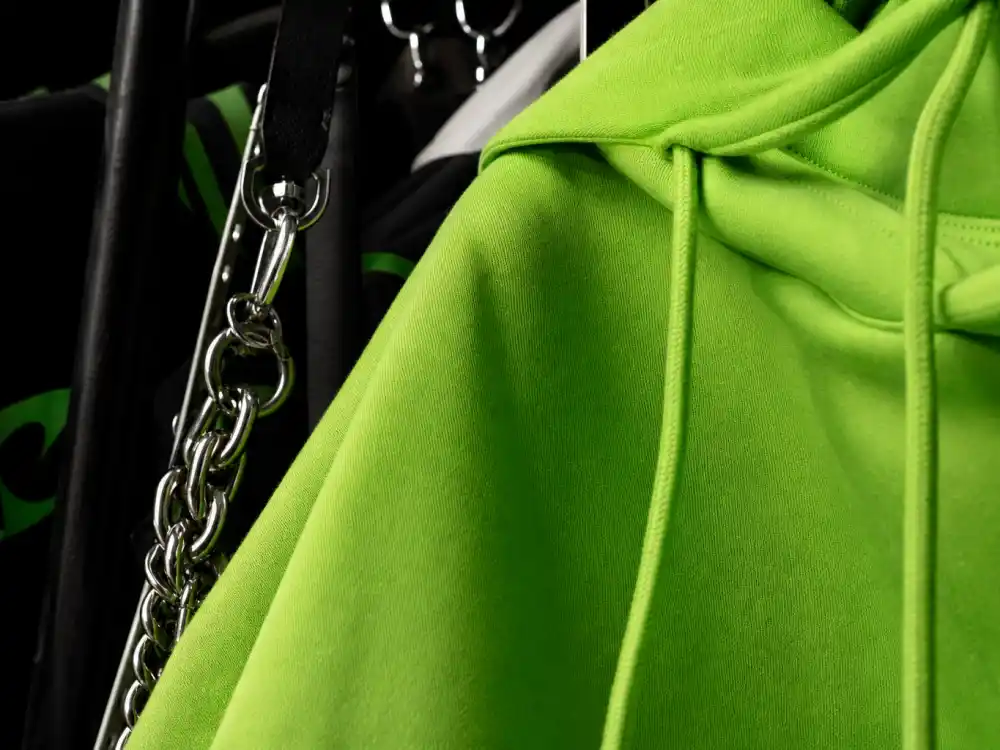 Oversized neon green hoodie on rack central to how to dress like Billie Eilish oversized style hoodie layering codes