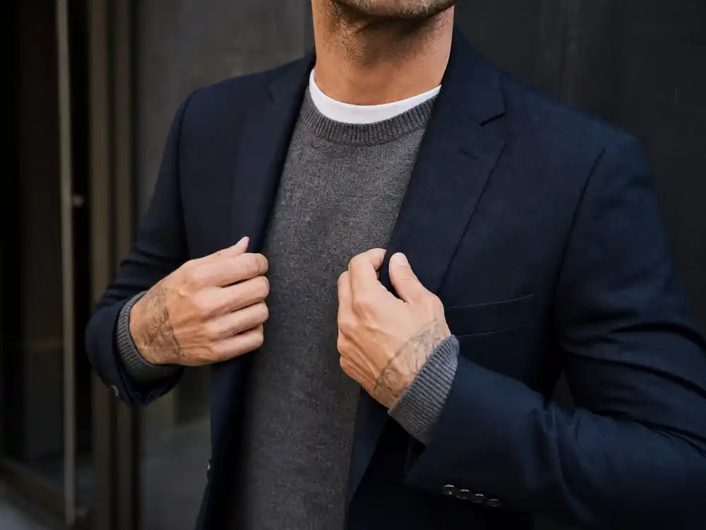 Navy blazer over grey sweater and white tee layering behind how to dress like David Beckham smart casual depth codes