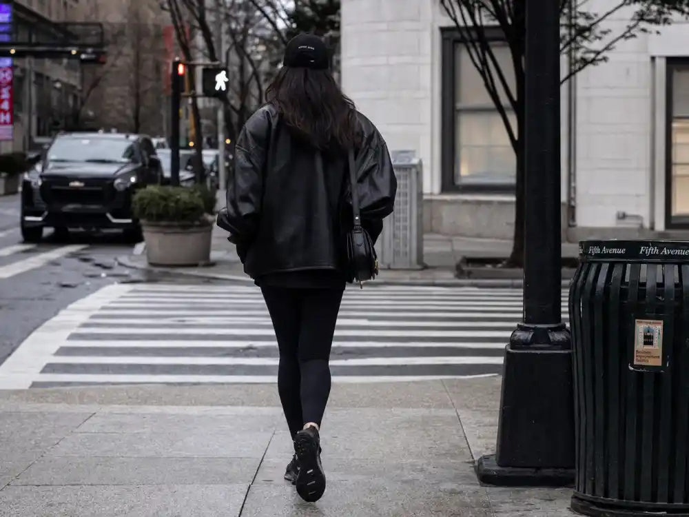 All-black leather jacket leggings and baseball cap behind how to dress like Gigi Hadid street style monochrome uniform
