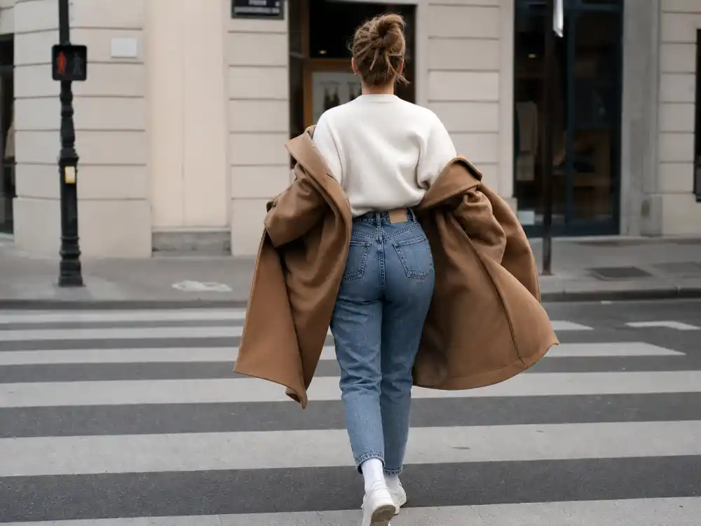 Oversized camel wool coat over cream sweater central to how to dress like Gigi Hadid street style outerwear codes
