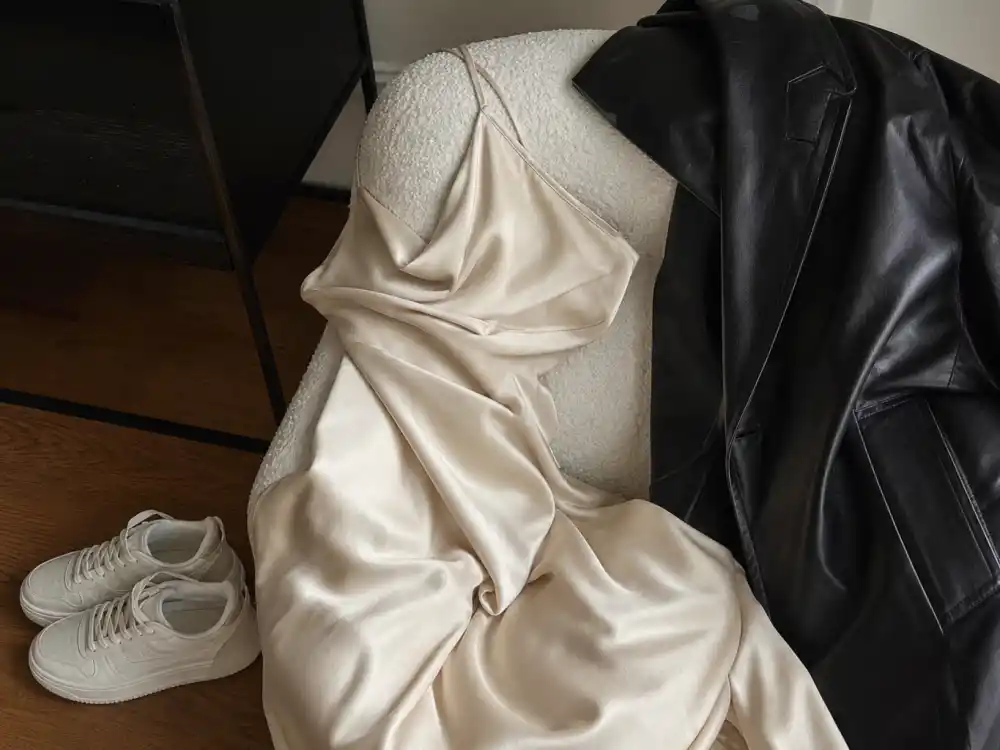 Champagne silk slip dress with leather jacket and sneakers for how to dress like Hailey Bieber off duty minimalist layers