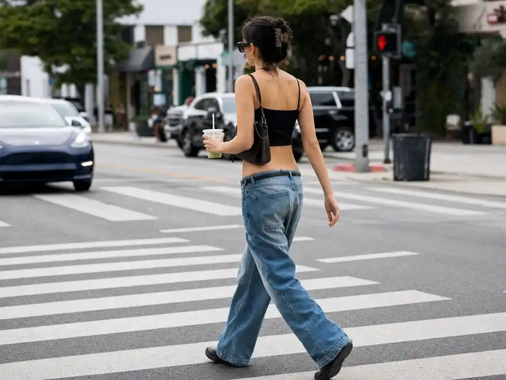 Baggy low-rise jeans and crop top street style central to how to dress like Hailey Bieber off duty paparazzi looks