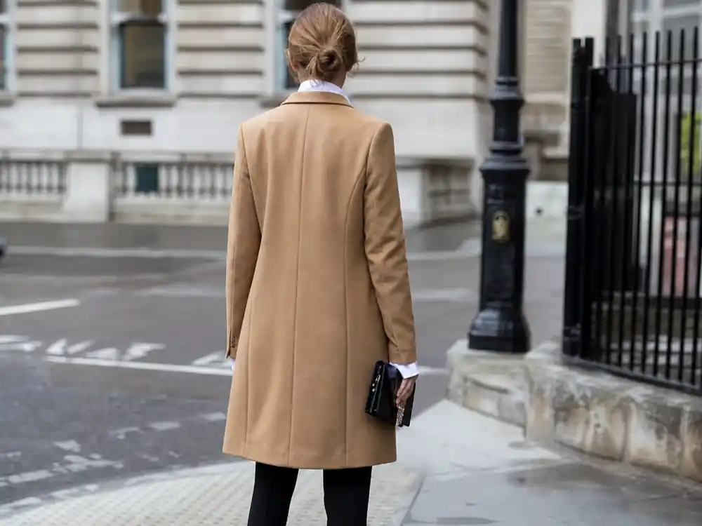 Tailored camel wool coat over crisp shirt central to how to dress like Olivia Palermo street style outerwear codes