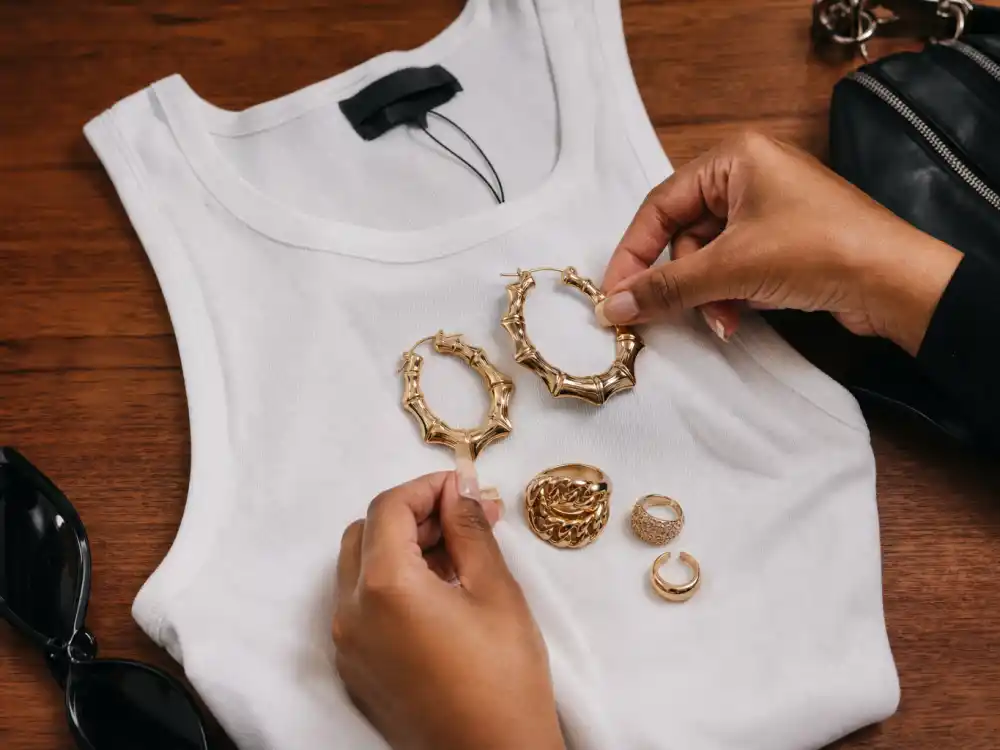 Gold statement earrings on simple white tank showing how to dress like Rihanna on a budget accessory elevation