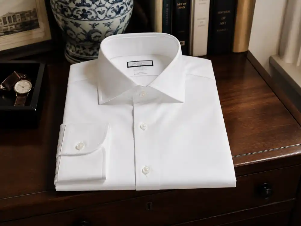 Crisp white oxford dress shirt with spread collar defining how to dress like Ryan Gosling classic menswear shirt rotation