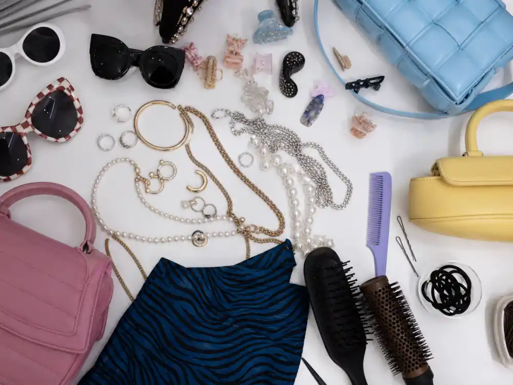 Accessory editing flat lay for Irene Kim celebrity stylist fashion with statement sunglasses colorful bags layered jewelry and styling tools