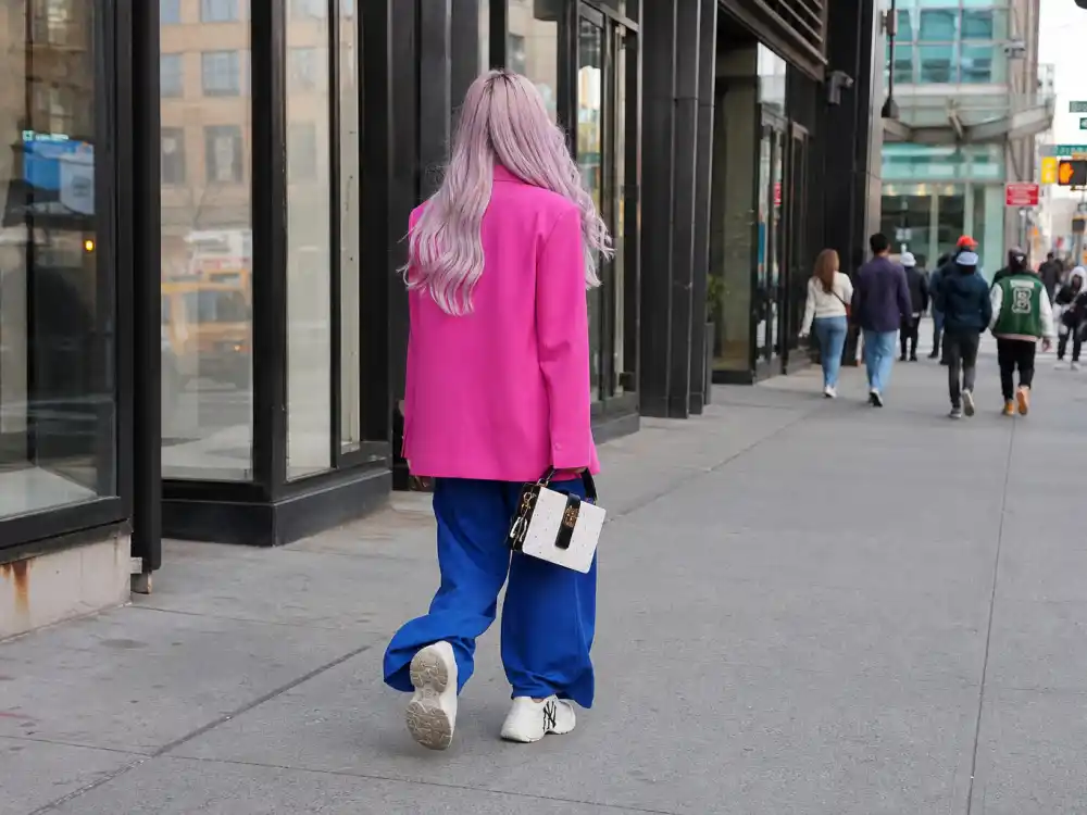 Colorful street style central to Irene Kim celebrity stylist fashion with pink blazer cobalt trousers and pastel hair from behind on urban sidewalk