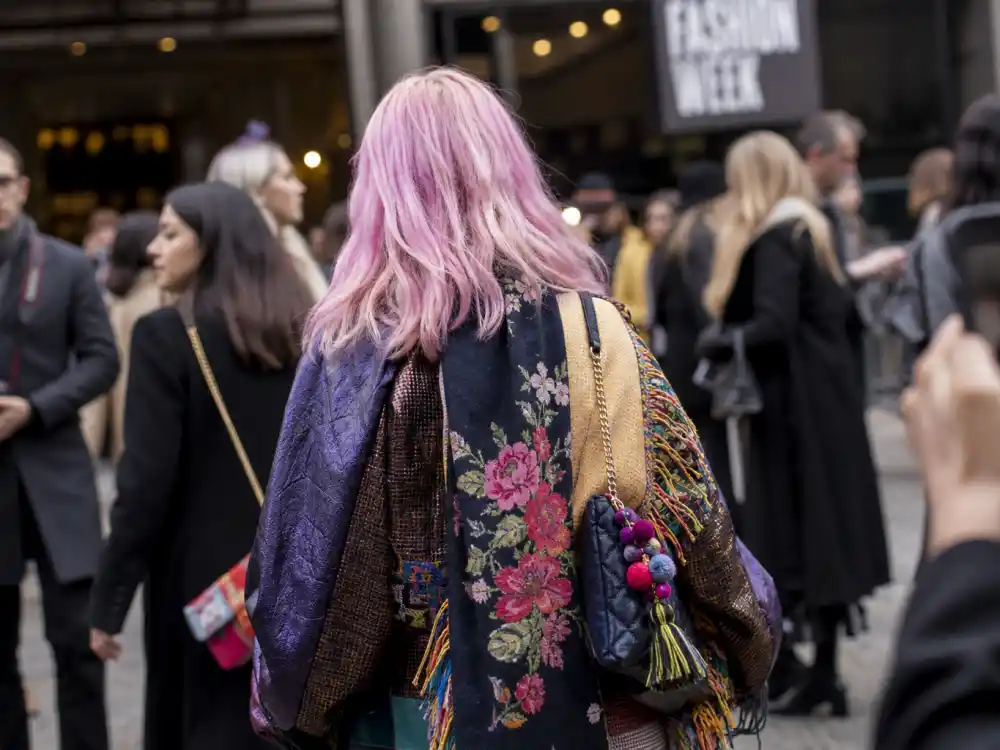 Pastel hair color era defining Irene Kim celebrity stylist fashion with lavender-pink dye and eclectic layered coat at fashion week from behind