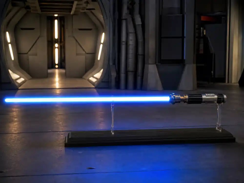 A sci-fi soundstage with a glowing prop blade, evoking the Star Wars prequel era when Jake Lloyd played young Anakin Skywalker
