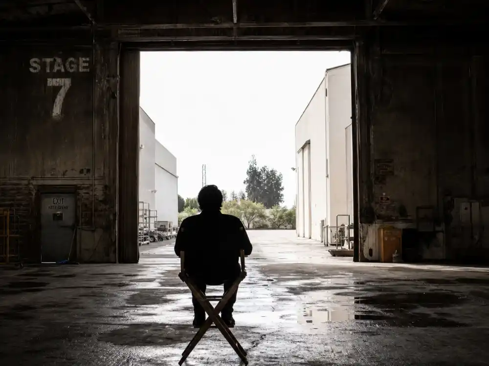 An abandoned film soundstage with daylight through an open door, symbolizing how Jake Lloyd stepped away from acting