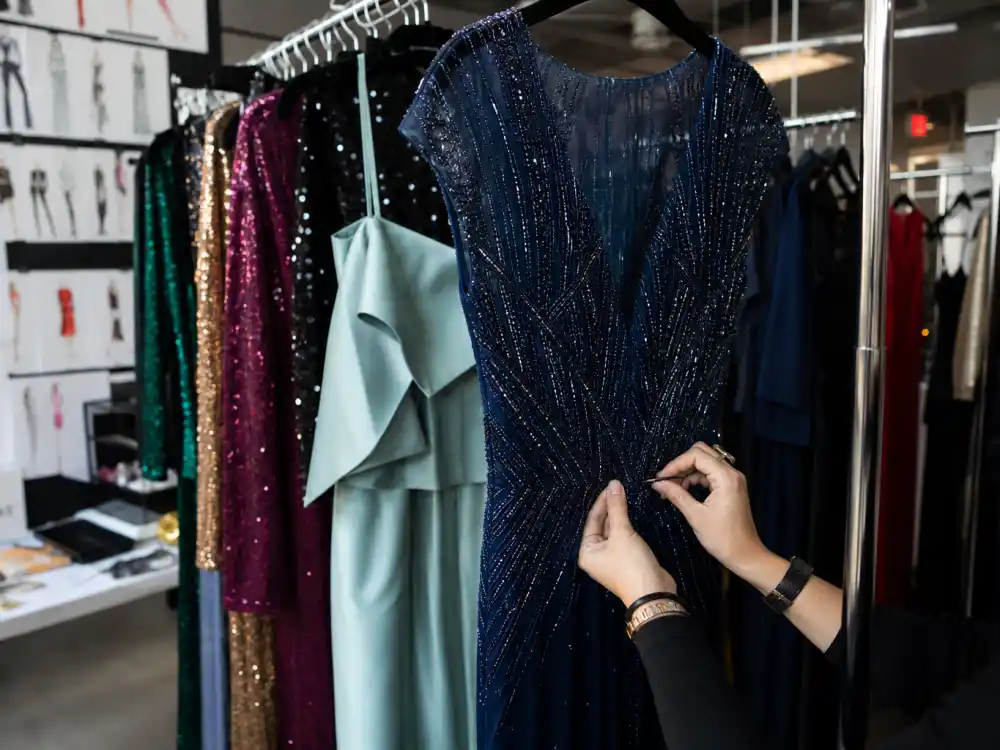 Rolling racks of jewel-tone red carpet gowns in a celebrity styling closet illustrating Jason Bolden celebrity stylist red carpet client wardrobe preparation