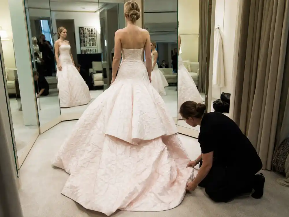 Couture fitting room preparation behind Jennifer Lawrence tripping Oscars dress custom Dior hem work and red-carpet rehearsal discipline
