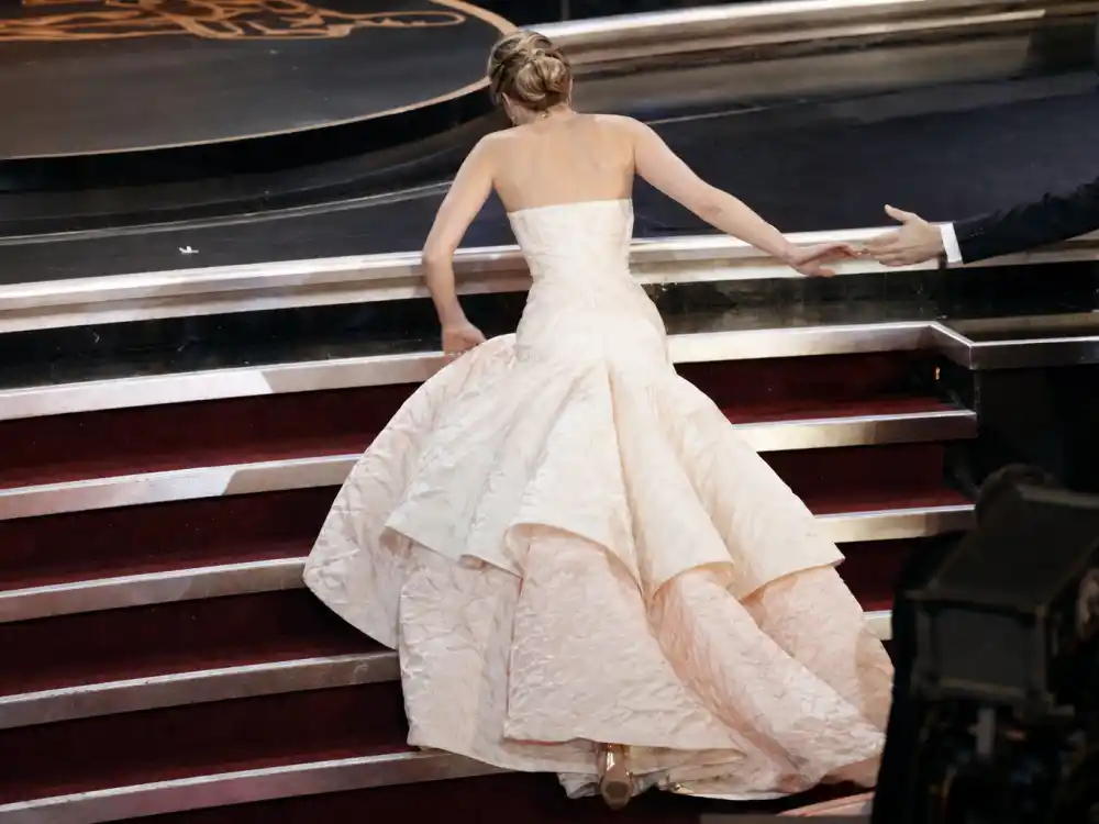 Marble Oscar ceremony stairs and red carpet runner where Jennifer Lawrence tripping Oscars dress stumble became a global viral fashion headline