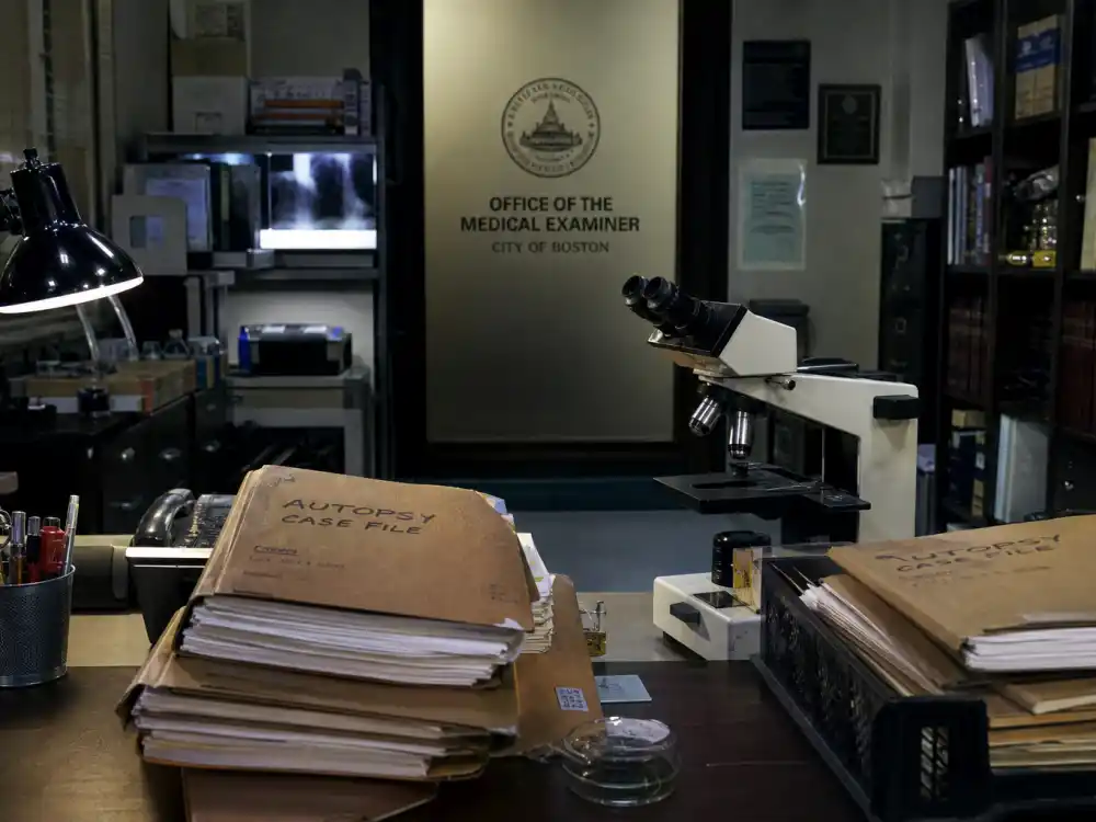 A medical examiner office desk with case files for Jerry O'Connell Crossing Jordan Woody Hoyt years