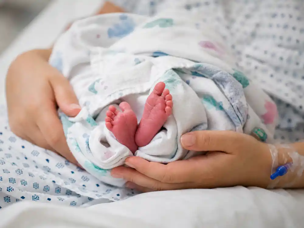 Hospital newborn hands cradle for John Legend Chrissy Teigen new baby 2025 guide — Esti Maxine Stephens born Jan 13 2023 via C-section Chrissy carried