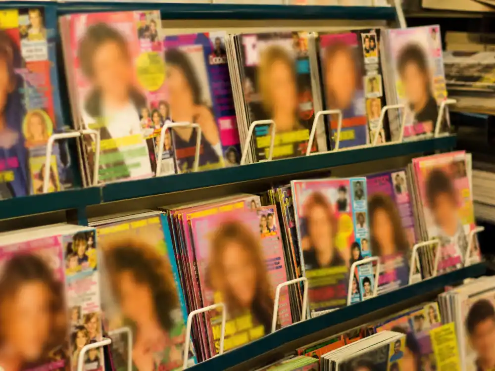 A 1990s newsstand magazine rack evoking the Jonathan Taylor Thomas teen heartthrob magazine-cover era