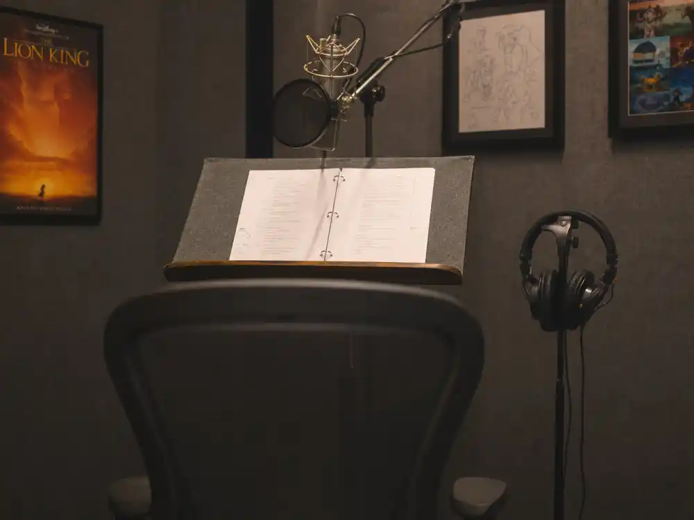 A voice-over recording booth with microphone and script pages for Jonathan Taylor Thomas as young Simba in The Lion King