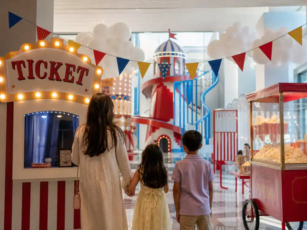 Carnival ticket booth and popcorn cart for Kardashian kids birthday parties over the top StormiWorld amusement-park theme verified by People
