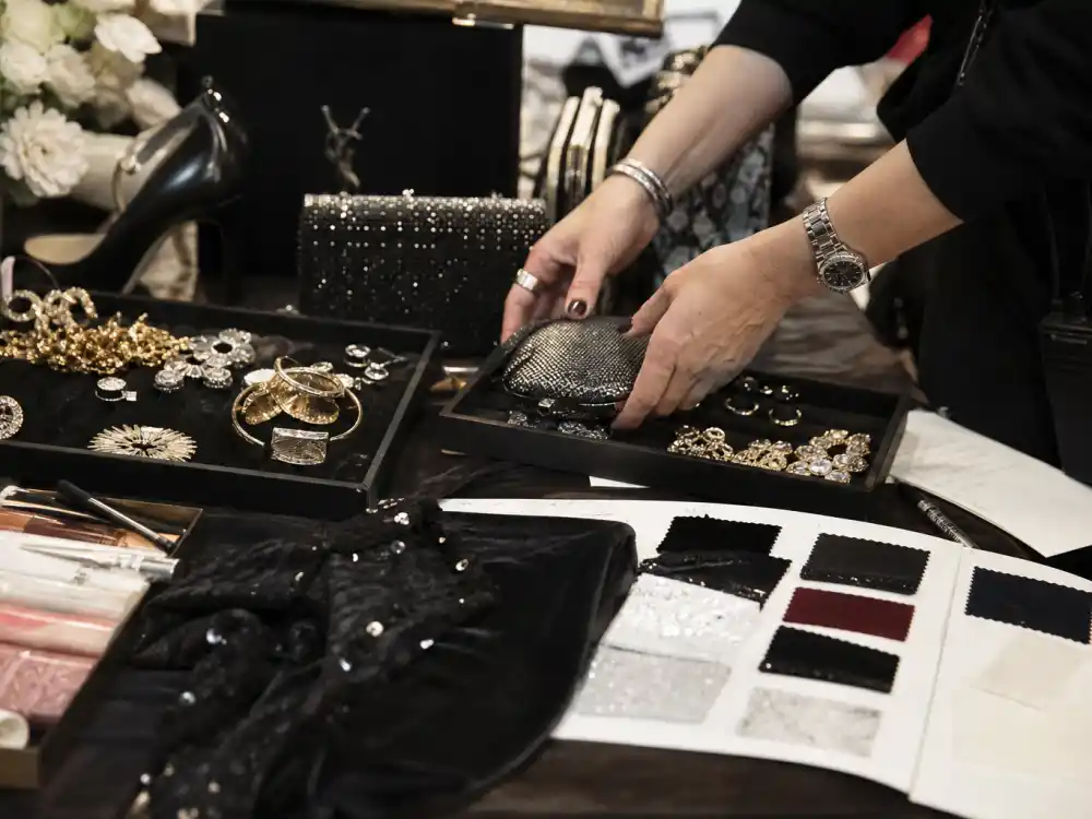 Styling vanity with jewelry trays, clutch bags, and fabric swatches showing accessory prep behind Karla Welch celebrity stylist clients red carpet finishing touches