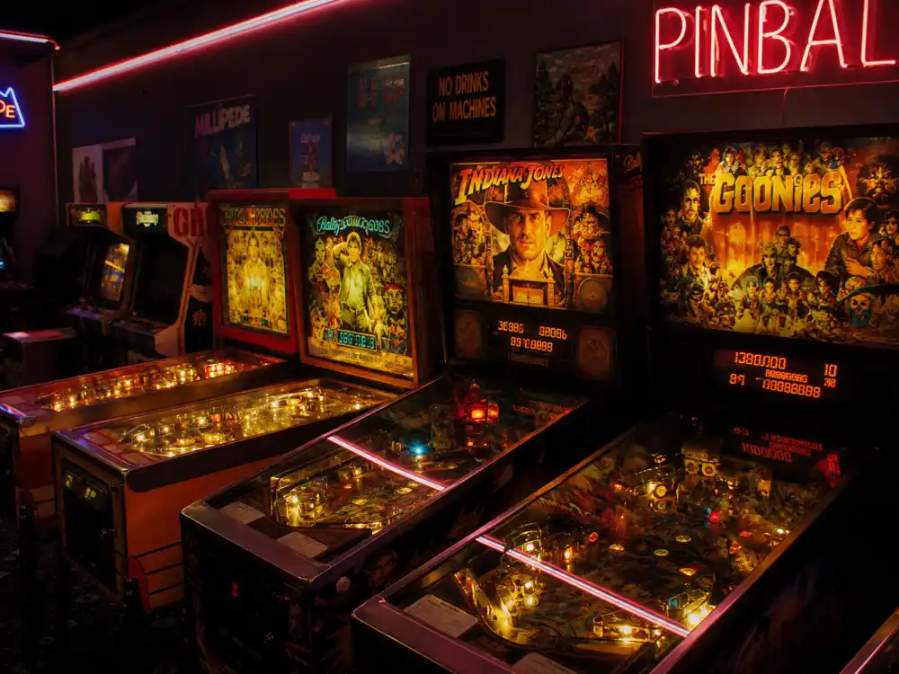 A 1980s arcade with pinball machines evoking Ke Huy Quan The Goonies Data child-actor fame