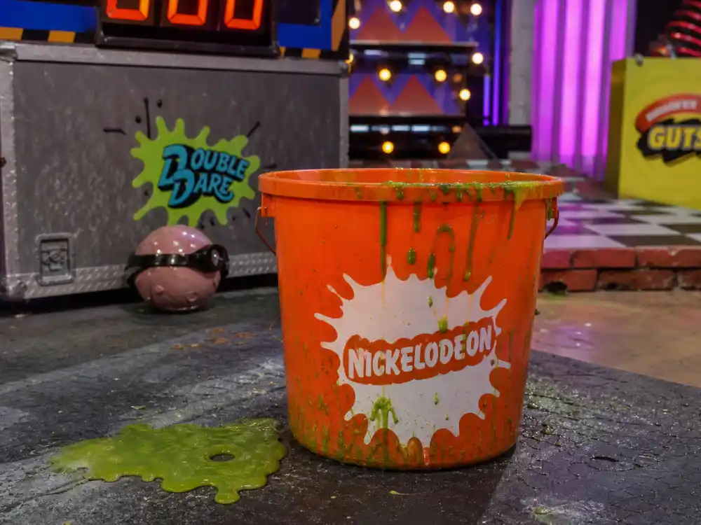 Orange slime bucket and 90s kids TV studio props for where is Kel Mitchell now Nickelodeon legacy