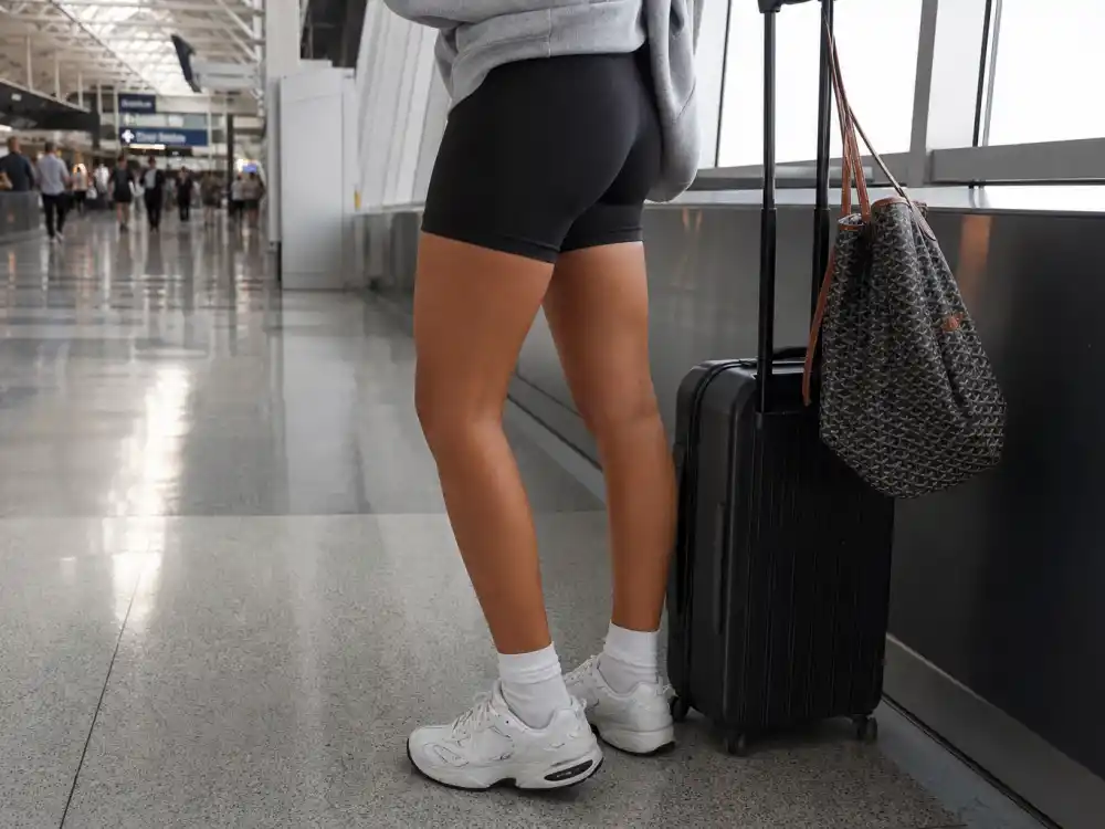 Black biker shorts with oversized hoodie hem defining Kendall Jenner airport style 2026 proportion play