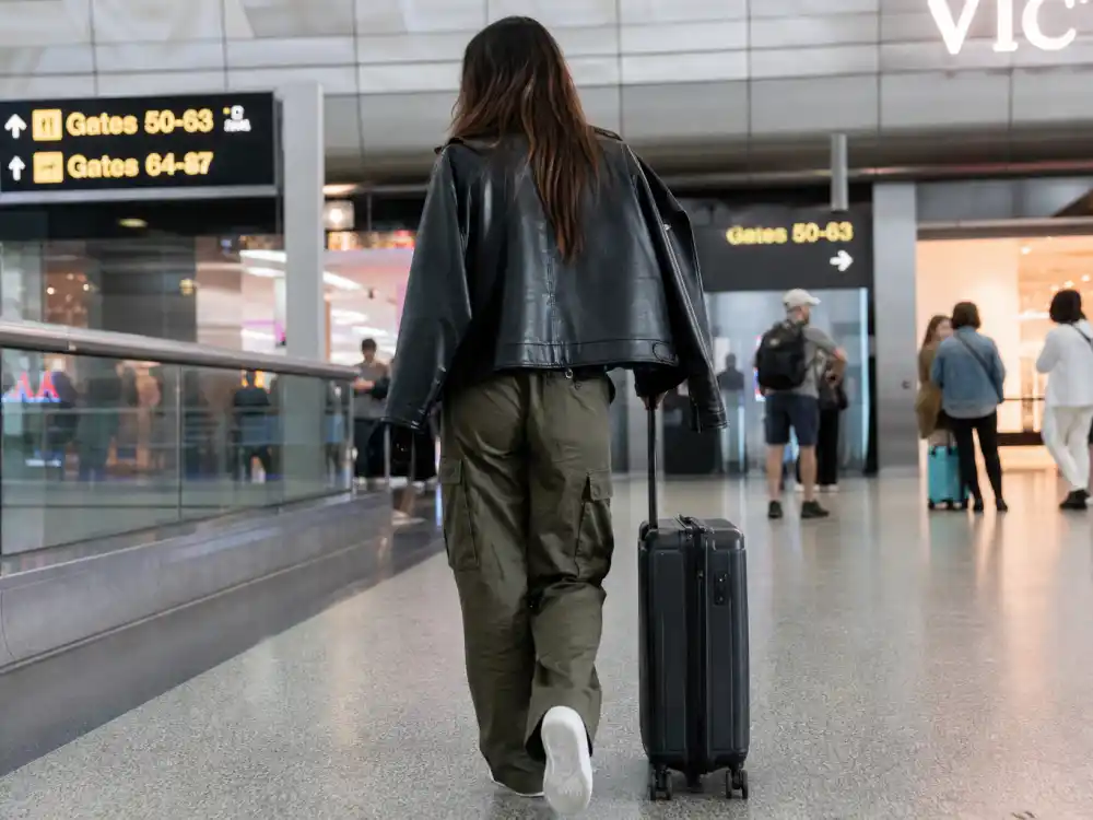 Olive cargo pants and leather jacket rotation behind Kendall Jenner airport style 2026 utility dressing