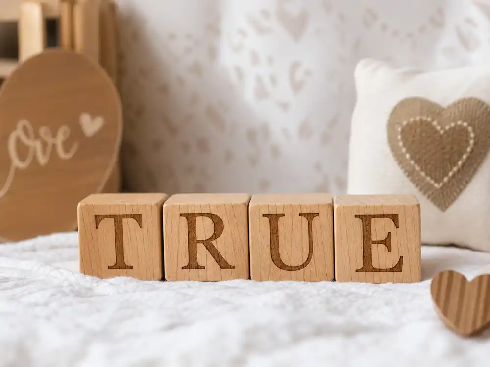 TRUE letter blocks on nursery blanket for Khloe Kardashian kids True and Tatum guide name meaning honesty symbolism