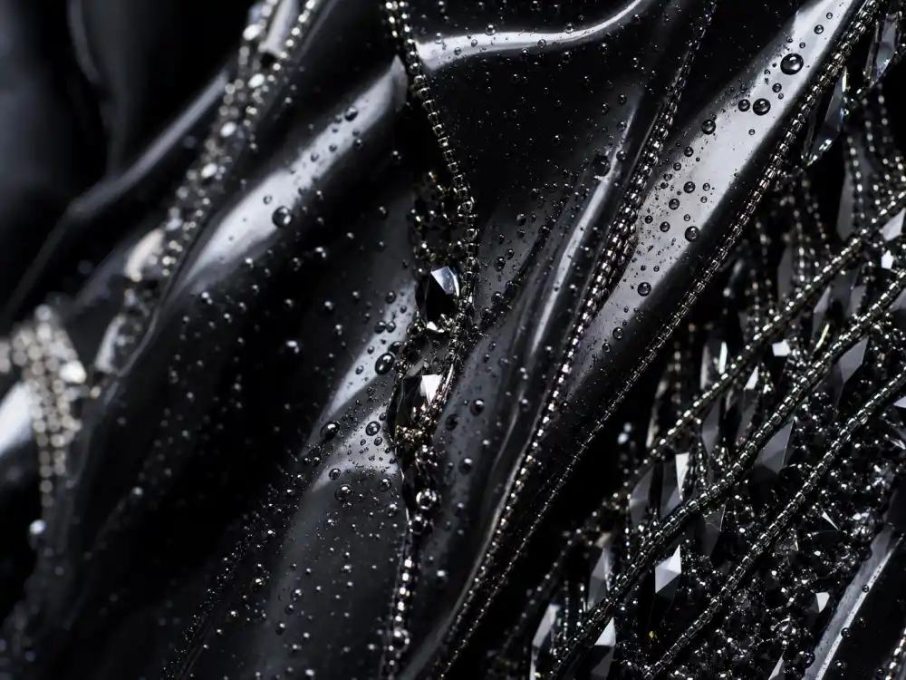 Glossy wet-look latex fabric with water droplet effect and crystal beading defining the Kim Kardashian wet dress Met Gala couture detail