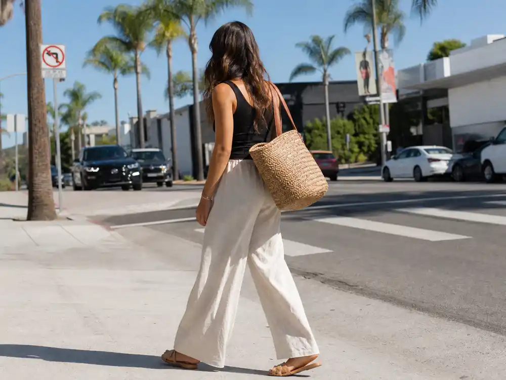 Wide-leg cream linen pants and black rib tank showing LA celebrity street style looks warm-weather polish