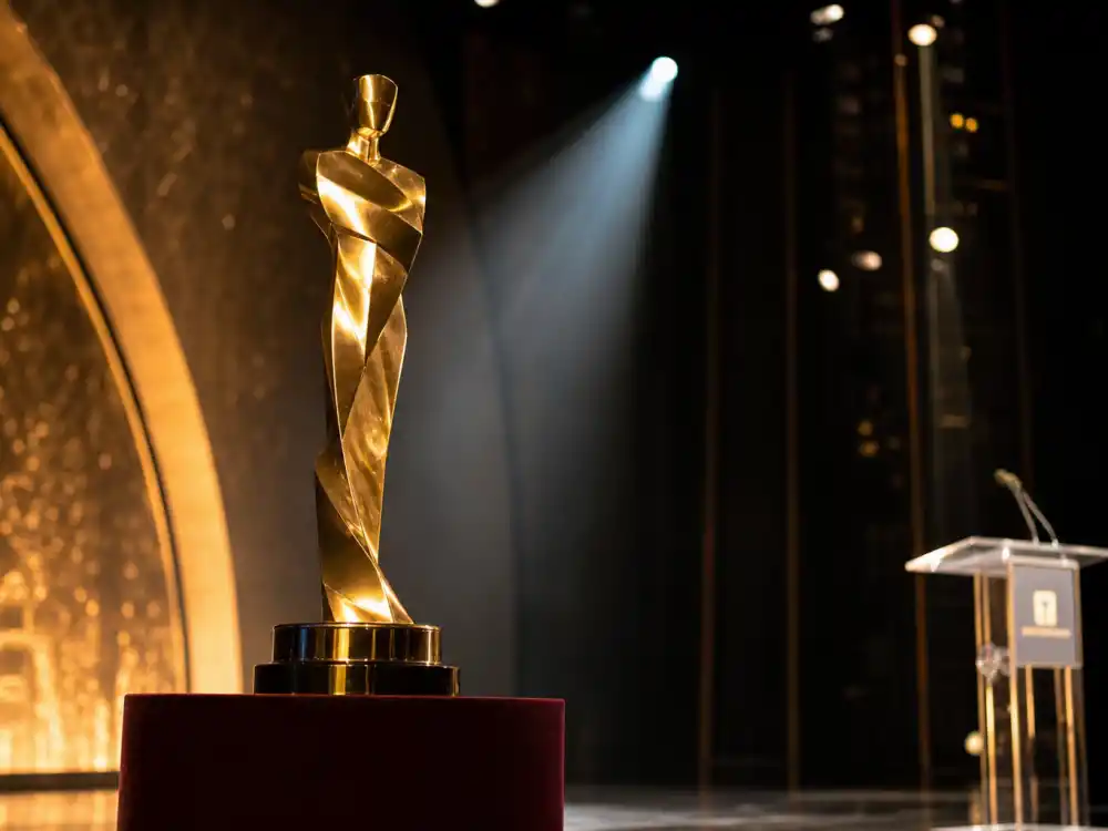 Golden awards statuette silhouette on stage symbolizing the La La Land Moonlight best picture mistake and Moonlight's eventual win