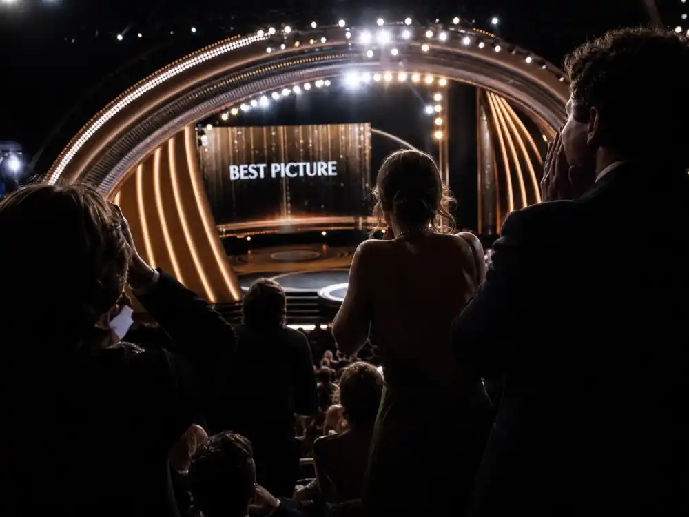 Shocked audience silhouettes reacting during the La La Land Moonlight best picture mistake correction at the Dolby Theatre