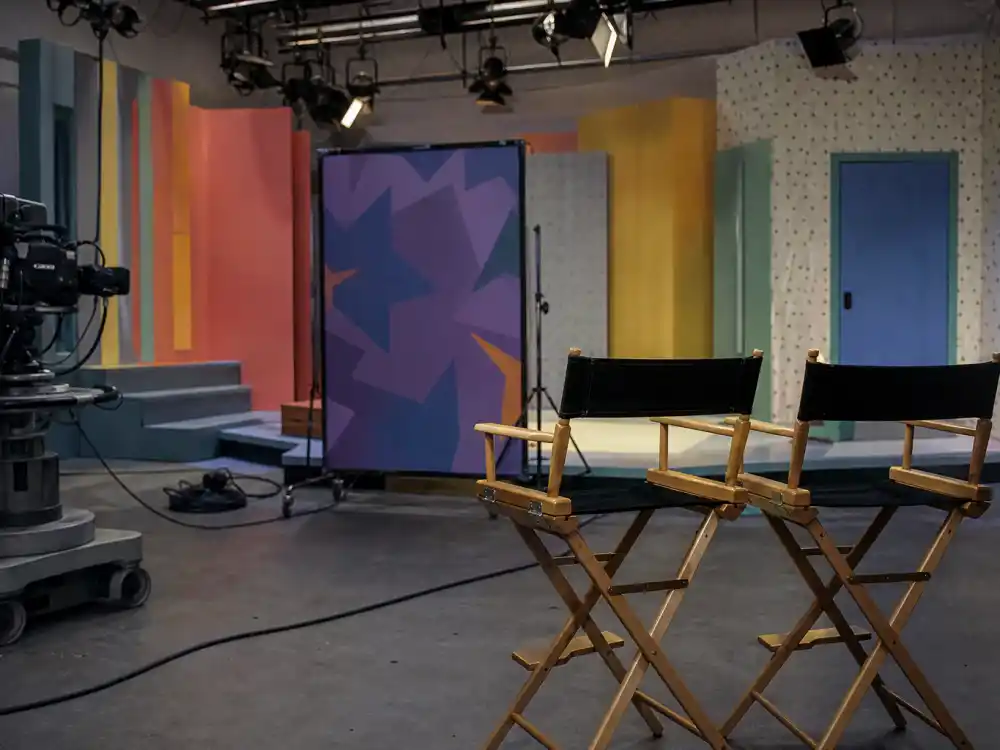 A colorful 1990s kids TV studio set evoking Larisa Oleynik Nickelodeon child-star era on Alex Mack