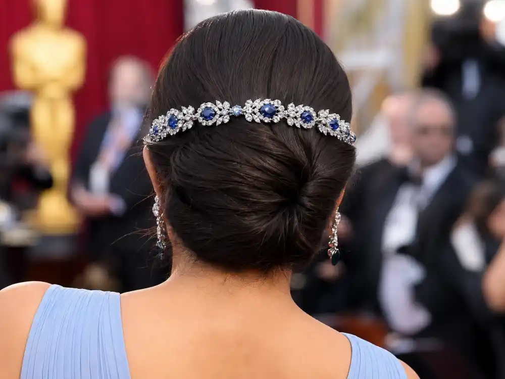 Fred Leighton diamond headband accessory paired with the Lupita Nyongo blue Oscars gown — elegant jewelry detail on powder blue pleated strap