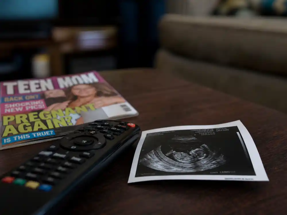 Ultrasound print beside TV remote for Mackenzie Ziegler baby announcement 2025 — Teen Mom Mackenzie McKee twins news often confused with Dance Moms alum Kenzie