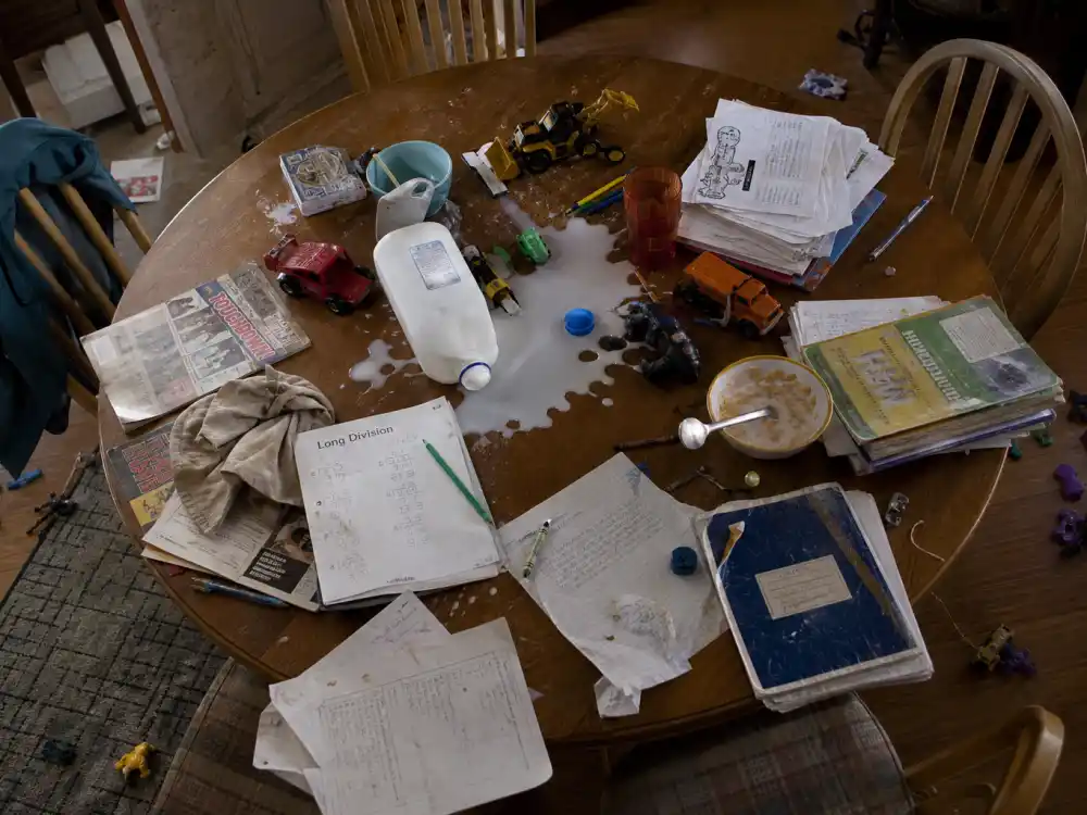 Messy dining table with homework and spilled milk evoking Malcolm in the Middle cast where are they now family chaos