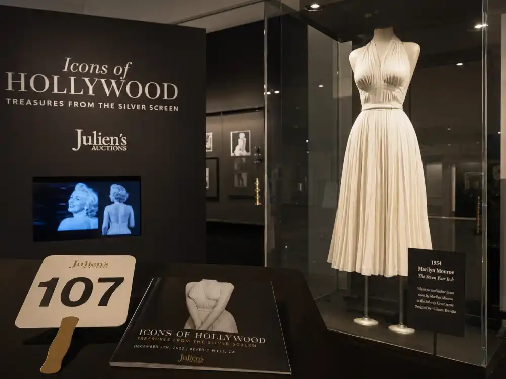 Fashion auction and museum display preserving Marilyn Monroe white dress history legacy — white pleated 1950s dress in glass exhibition case