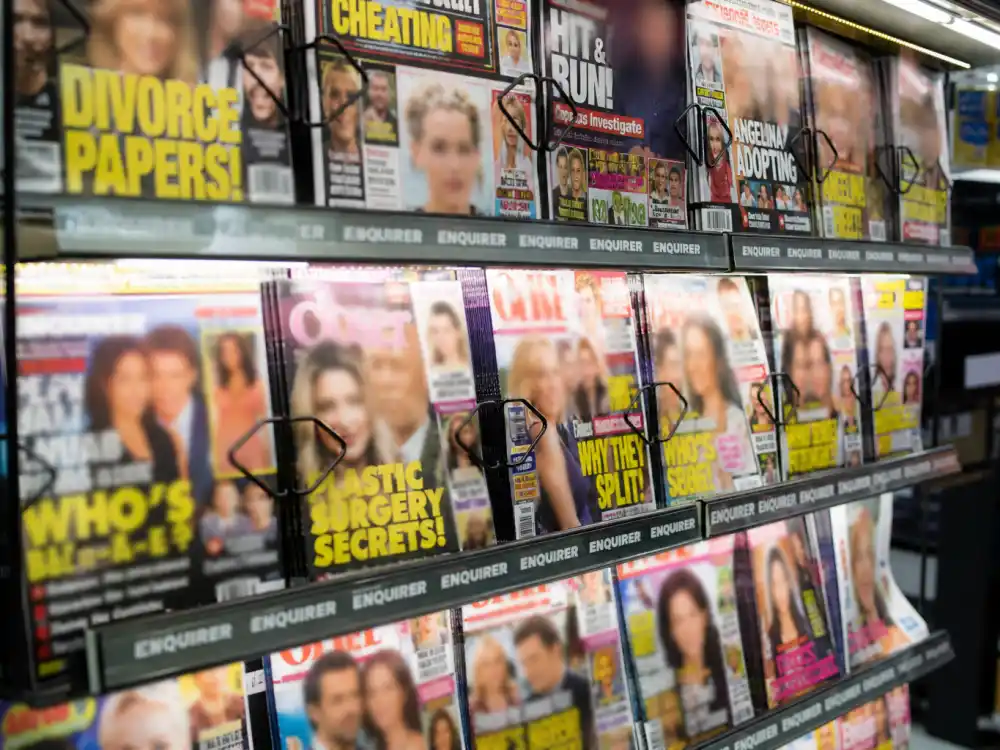 Tabloid magazine rack with blurred headlines about the difficult narrative that shaped what happened to Megan Fox career