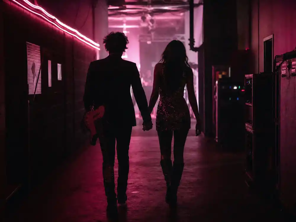 Backstage silhouettes holding hands representing how Megan Fox career intersected with her Machine Gun Kelly relationship