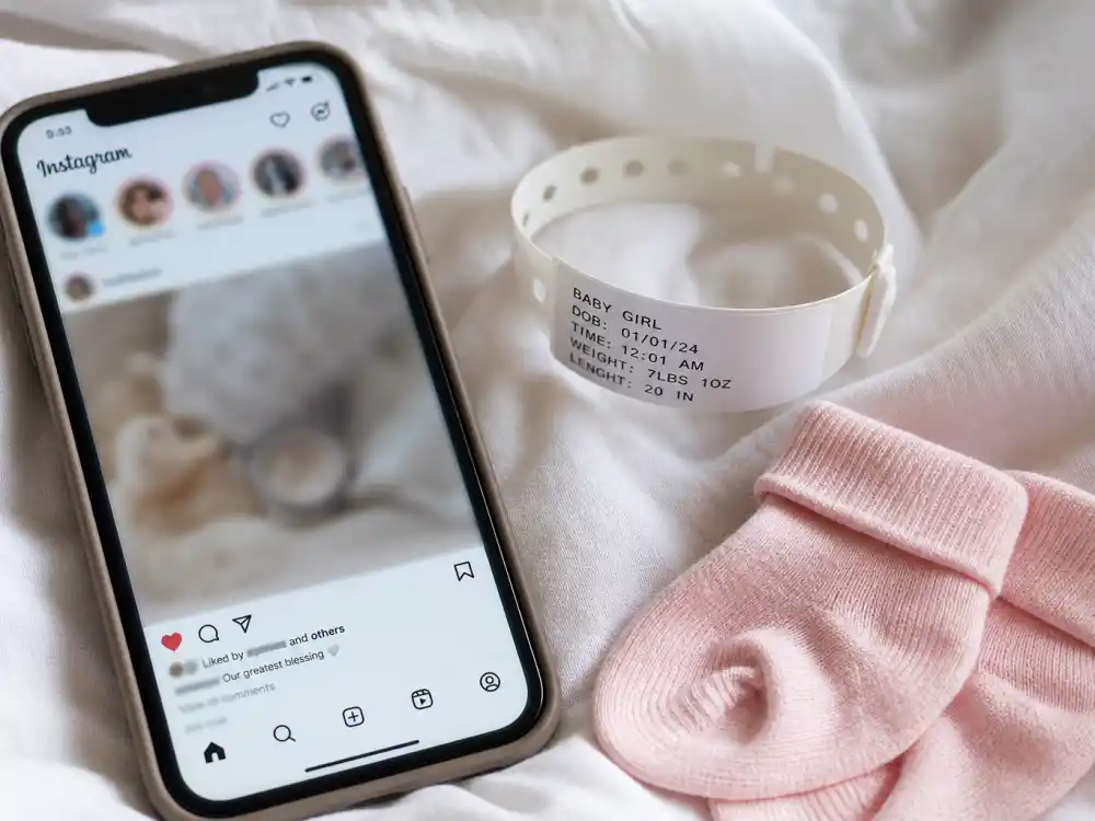 Phone beside hospital bracelet and tiny pink socks — Meghan Trainor baby announcement 2026 Instagram reveal format fans recognized instantly