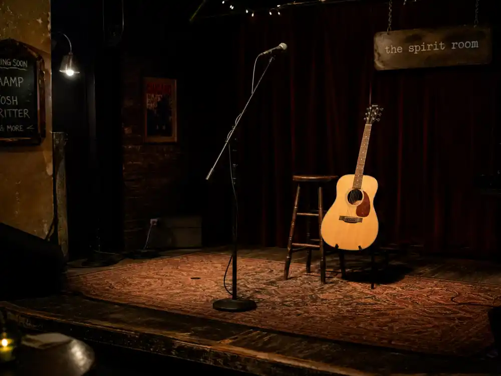 Empty coffeehouse stage with acoustic guitar for what happened to Michelle Branch after The Spirit Room debut album