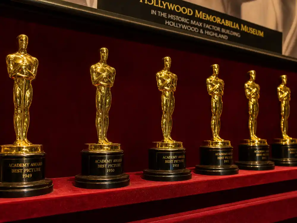 Golden film award trophies on velvet shelf for most awarded celebrities of all time Oscar record leaderboard